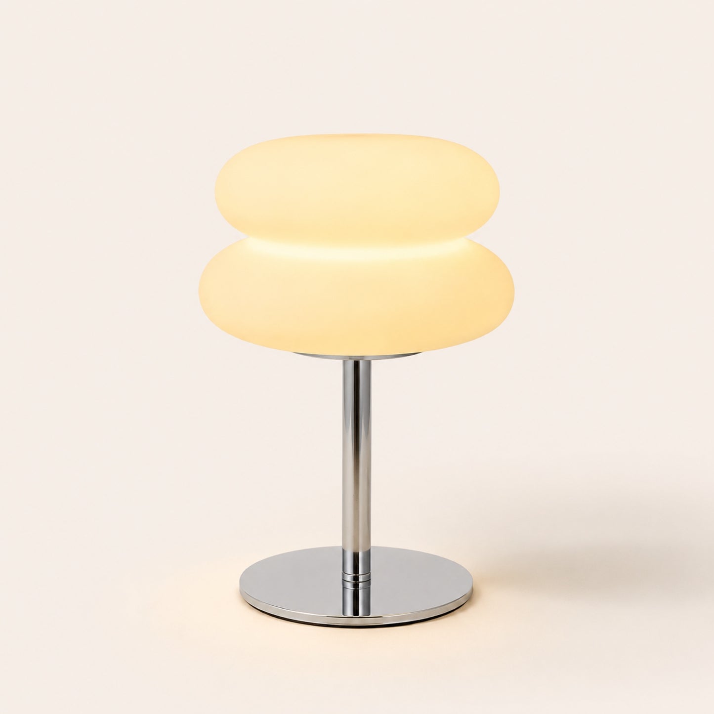 The Mushroom opal glass lamp with chrome stem, lit, on warm porcelain background
