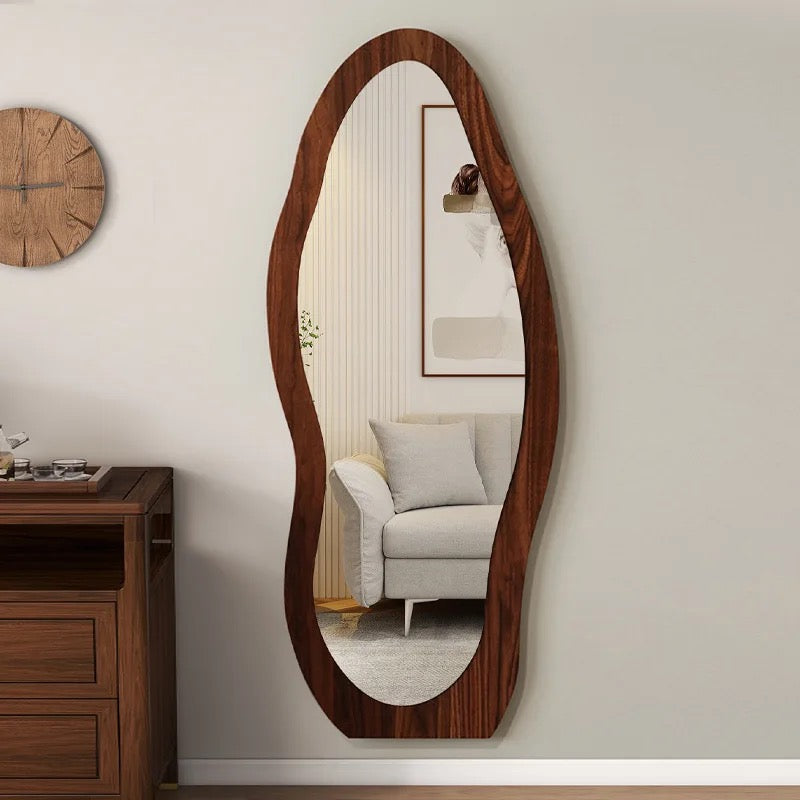 The Wave mirror in walnut reflecting a living room